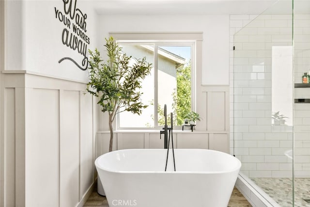 3192 Sawyers Bar Ln, Chico, CA 95973 - bathroom with a freestanding bath, wood finished floors, tiled shower, a decorative wall, and a wainscoted wall