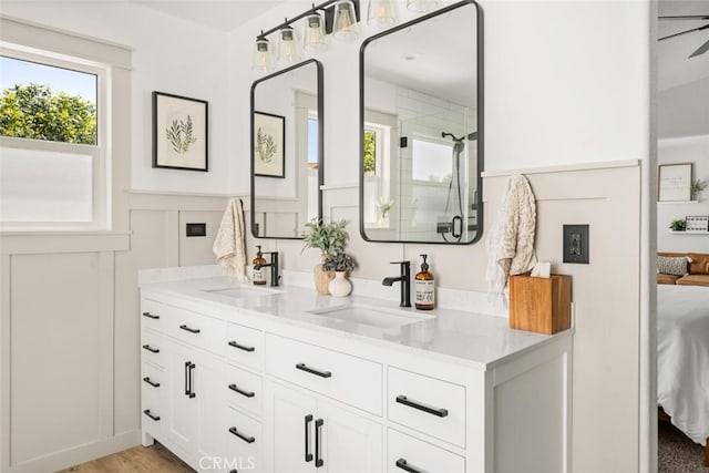 3192 Sawyers Bar Ln, Chico, CA 95973 - ensuite bathroom with double vanity, plenty of natural light, an enclosed shower, a decorative wall, and a wainscoted wall