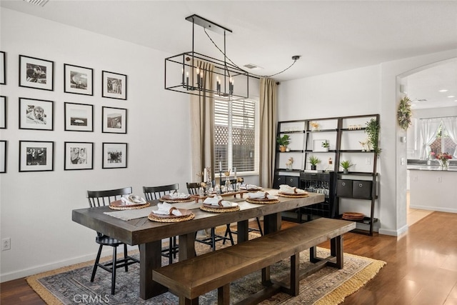 3192 Sawyers Bar Ln, Chico, CA 95973 - dining area with a chandelier, wood finished floors, and arched walkways