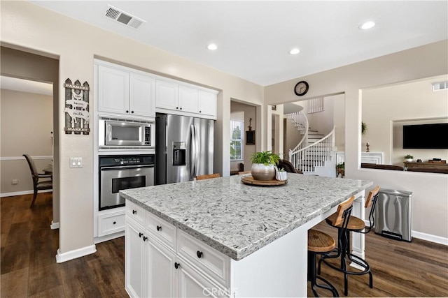31956 Via Del Paso, Winchester, CA 92596 - kitchen featuring stainless steel appliances, dark wood-style flooring, light stone countertops, white cabinets, and recessed lighting