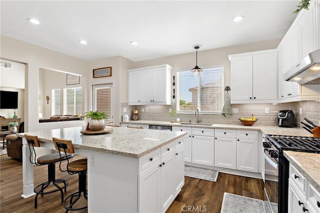 31956 Via Del Paso, Winchester, CA 92596 - kitchen featuring gas stove, a kitchen island, dark wood-style floors, white cabinets, and recessed lighting