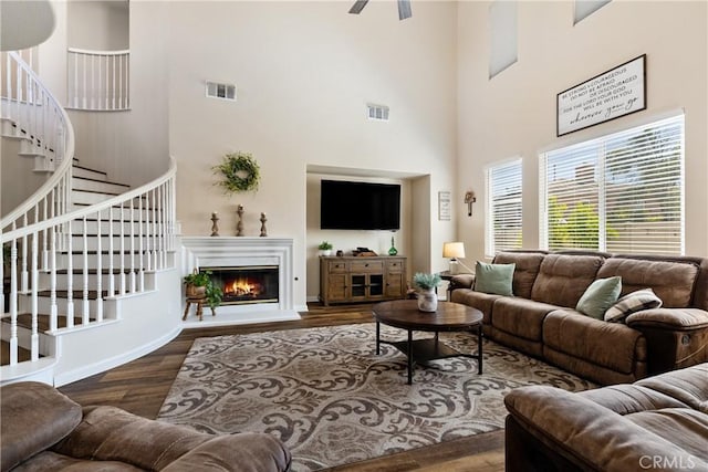 31956 Via Del Paso, Winchester, CA 92596 - living area featuring a high ceiling, stairs, wood finished floors, a glass covered fireplace, and a ceiling fan
