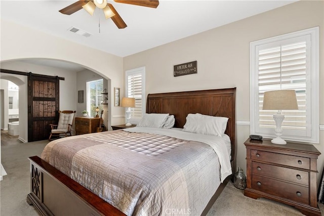 31956 Via Del Paso, Winchester, CA 92596 - bedroom featuring light carpet, a barn door, arched walkways, a ceiling fan, and connected bathroom