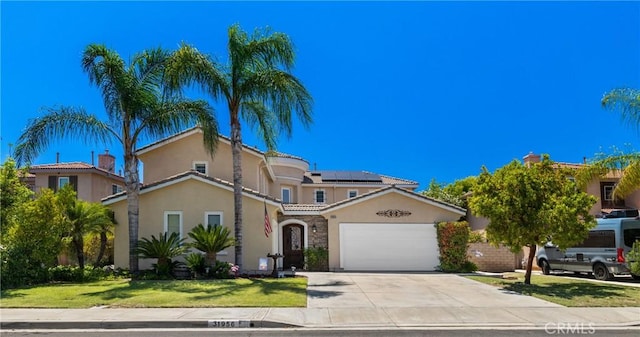 31956 Via Del Paso, Winchester, CA 92596 - mediterranean / spanish home featuring stucco siding, roof mounted solar panels, a garage, driveway, and a front yard