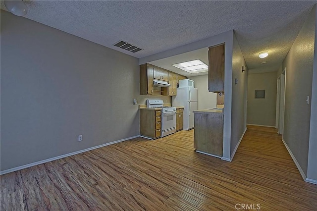 1209 Edwards St Unit 56, Redlands, CA 92374 - kitchen featuring white appliances, wood finished floors, under cabinet range hood, a textured ceiling, and light countertops