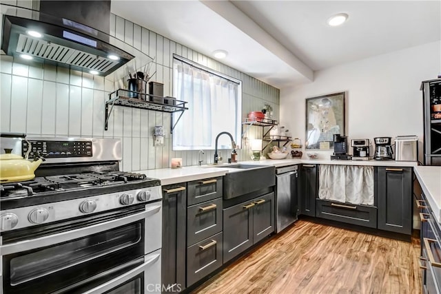 458 Termino Ave, Corona, CA 92879 - kitchen featuring appliances with stainless steel finishes, wall chimney range hood, light countertops, light wood finished floors, and recessed lighting