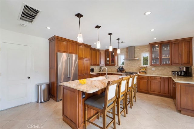 19622 Crestknoll Dr, Yorba Linda, CA 92886 - kitchen with high end fridge, wall chimney range hood, brown cabinetry, decorative backsplash, and light stone countertops