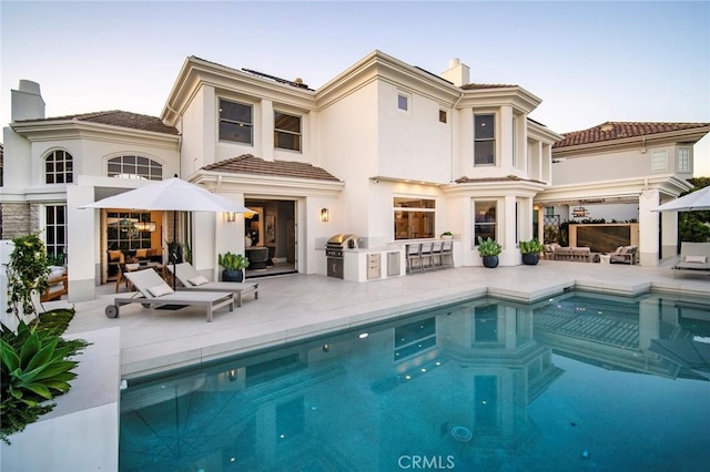 4 Ebony Glade, Laguna Niguel, CA 92677 - back of house with exterior kitchen, a chimney, a patio, an outdoor pool, and an outdoor hangout area