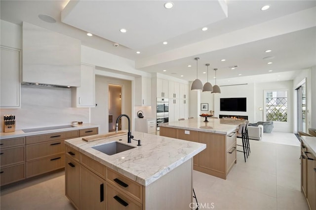 4 Ebony Glade, Laguna Niguel, CA 92677 - kitchen with a large island with sink, black electric stovetop, open floor plan, recessed lighting, and light stone counters