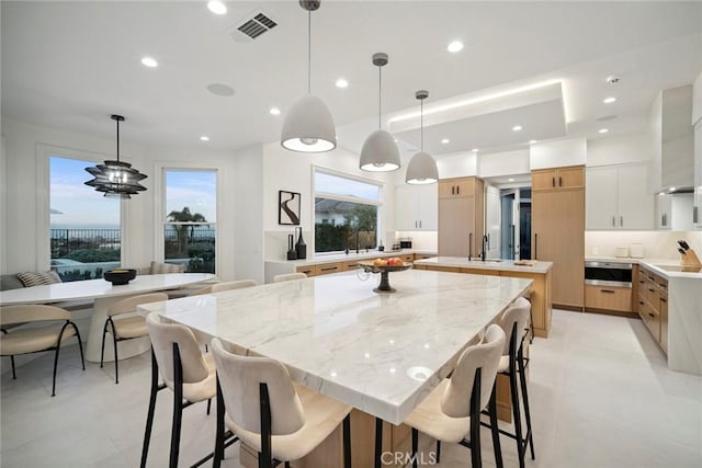 4 Ebony Glade, Laguna Niguel, CA 92677 - kitchen featuring a spacious island, stainless steel microwave, electric cooktop, decorative light fixtures, and a breakfast bar