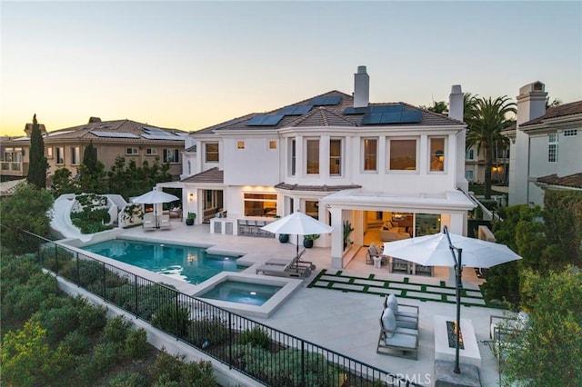 4 Ebony Glade, Laguna Niguel, CA 92677 - back of property at dusk with solar panels, a patio, and outdoor dining area