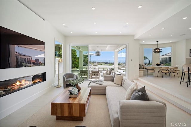 4 Ebony Glade, Laguna Niguel, CA 92677 - living area featuring healthy amount of natural light, recessed lighting, a glass covered fireplace, and a chandelier