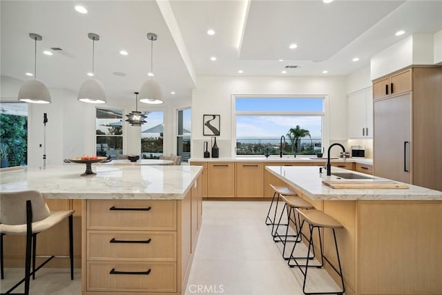 4 Ebony Glade, Laguna Niguel, CA 92677 - kitchen featuring a spacious island, light brown cabinetry, a breakfast bar area, light stone counters, and recessed lighting