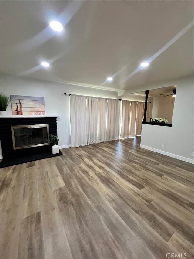 1135 W Coolfield Dr, Covina, CA 91722 - unfurnished living room featuring a glass covered fireplace, wood finished floors, and recessed lighting