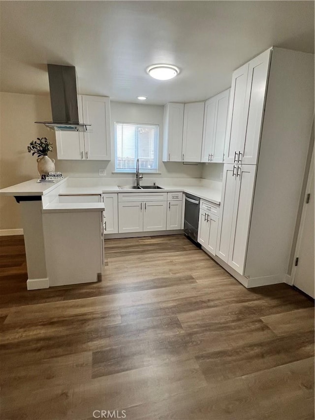 1135 W Coolfield Dr, Covina, CA 91722 - kitchen featuring wall chimney exhaust hood, stainless steel dishwasher, a peninsula, white cabinets, and light countertops