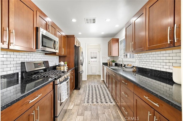 744 S 5th St, Montebello, CA 90640 - kitchen with appliances with stainless steel finishes, dark stone counters, recessed lighting, tasteful backsplash, and brown cabinets