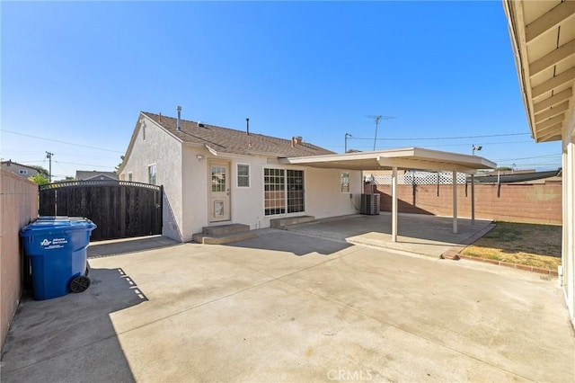 744 S 5th St, Montebello, CA 90640 - back of house featuring stucco siding, a fenced backyard, a patio area, and an attached carport