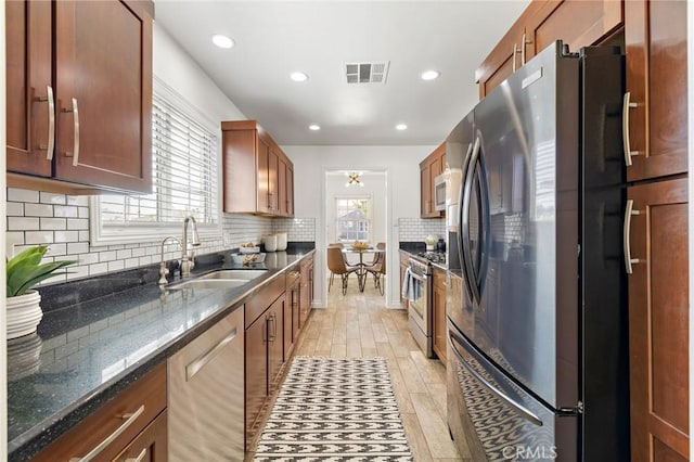 744 S 5th St, Montebello, CA 90640 - kitchen with appliances with stainless steel finishes, tasteful backsplash, dark stone countertops, recessed lighting, and brown cabinetry