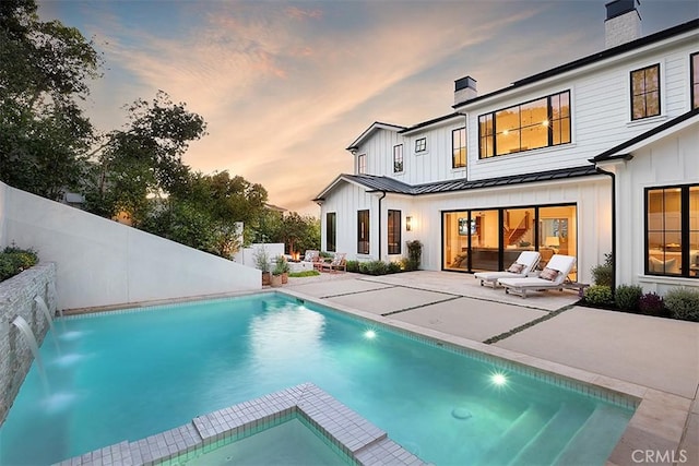 2001 Port Ramsgate Pl, Newport Beach, CA 92660 - rear view of house with a standing seam roof, a chimney, and board and batten siding