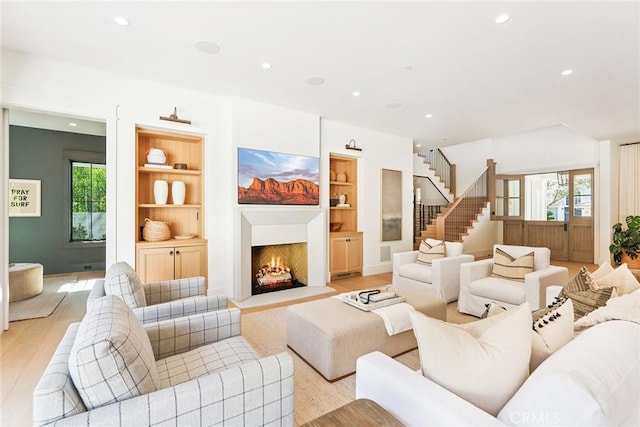 2001 Port Ramsgate Pl, Newport Beach, CA 92660 - living area featuring light wood-type flooring, stairway, recessed lighting, a warm lit fireplace, and built in features