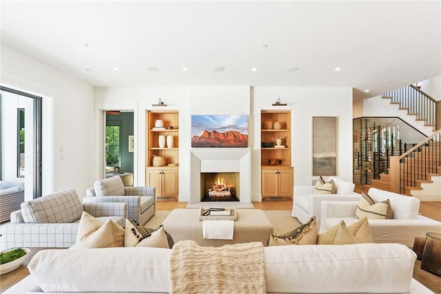 2001 Port Ramsgate Pl, Newport Beach, CA 92660 - living area featuring light wood-style flooring, stairs, a fireplace with flush hearth, recessed lighting, and built in shelves