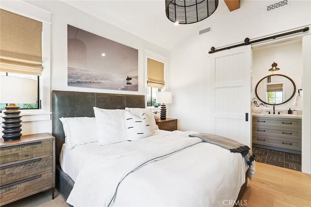 2001 Port Ramsgate Pl, Newport Beach, CA 92660 - bedroom with a barn door, vaulted ceiling, parquet flooring, and ensuite bathroom