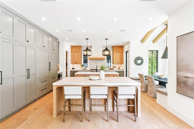 2001 Port Ramsgate Pl, Newport Beach, CA 92660 - kitchen with an island with sink, gray cabinets, light wood finished floors, backsplash, and recessed lighting