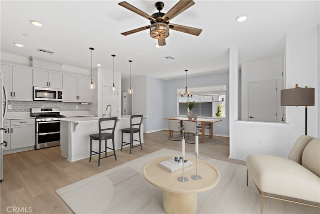 35115 Vine Pl, Fallbrook, CA 92028 - living room with a ceiling fan, light wood-style floors, recessed lighting, and a chandelier