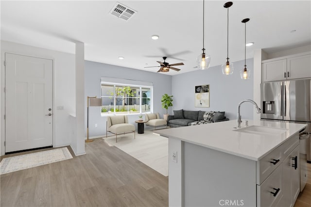 35115 Vine Pl, Fallbrook, CA 92028 - kitchen featuring light wood finished floors, a ceiling fan, open floor plan, hanging light fixtures, and a center island with sink