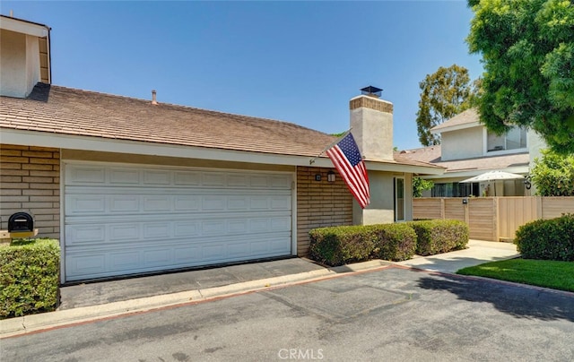 10 Glenhurst Unit 37, Irvine, CA 92604 - view of front of home featuring a chimney, driveway, and a garage