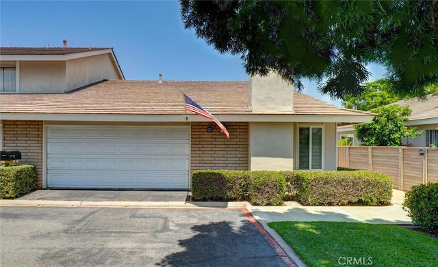 10 Glenhurst Unit 37, Irvine, CA 92604 - view of front of home with brick siding, driveway, stucco siding, and an attached garage