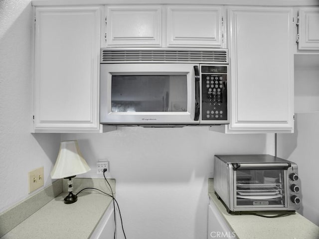11410 Dolan Unit 328, Downey, CA 90241 - kitchen view of stainless steel microwave, white cabinets, and light countertops