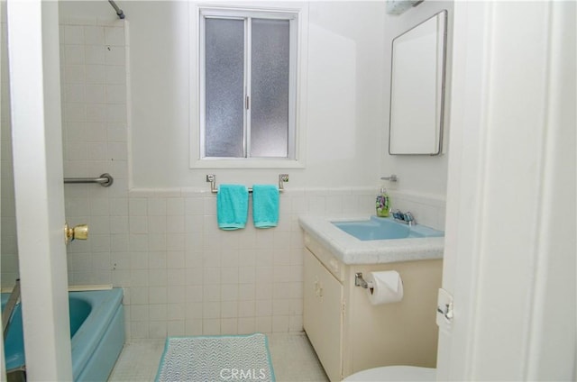 10520 Haskell Ave, Granada Hills, CA 91344 - bathroom featuring tile walls, vanity, tile patterned floors, a bath, and a wainscoted wall