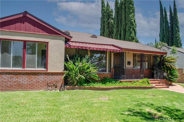 10520 Haskell Ave, Granada Hills, CA 91344 - view of front of property with brick siding, a front yard, and covered porch