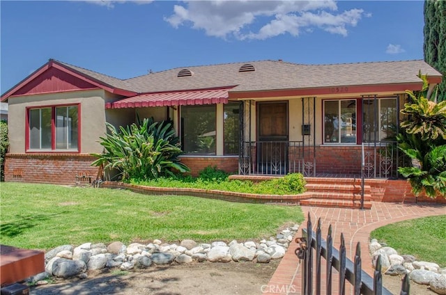 10520 Haskell Ave, Granada Hills, CA 91344 - view of front of property featuring brick siding, a front lawn, covered porch, and a shingled roof