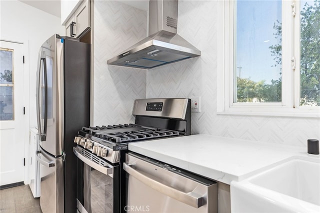 853 N Jasmine Ave, Ontario, CA 91762 - kitchen with wall chimney range hood, appliances with stainless steel finishes, decorative backsplash, light countertops, and light wood-style floors