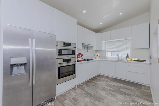 110 S Baymar St, West Covina, CA 91791 - kitchen featuring appliances with stainless steel finishes, vaulted ceiling, light countertops, light wood-style floors, and white cabinetry