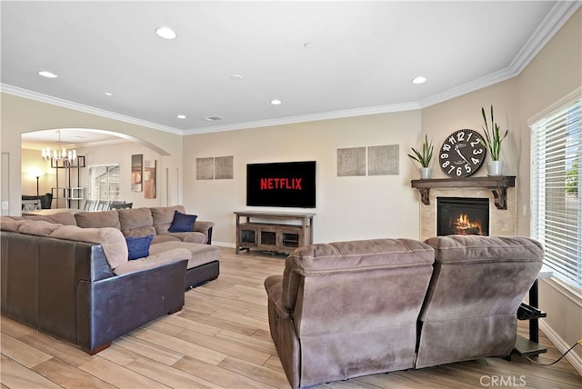 1018 W 15th St, Upland, CA 91786 - living room with a chandelier, arched walkways, plenty of natural light, a warm lit fireplace, and ornamental molding
