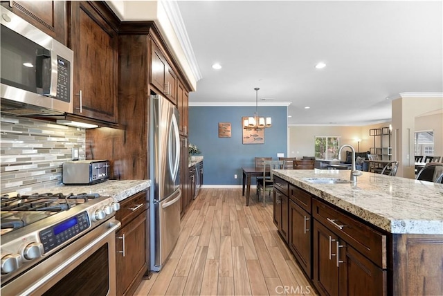 1018 W 15th St, Upland, CA 91786 - kitchen with appliances with stainless steel finishes, crown molding, a chandelier, decorative backsplash, and light wood-type flooring