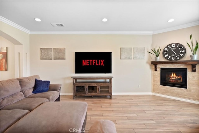 1018 W 15th St, Upland, CA 91786 - living area featuring crown molding, a tiled fireplace, wood finished floors, recessed lighting, and arched walkways