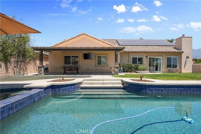 1018 W 15th St, Upland, CA 91786 - back of house with an outdoor hot tub, stucco siding, roof mounted solar panels, and a tile roof