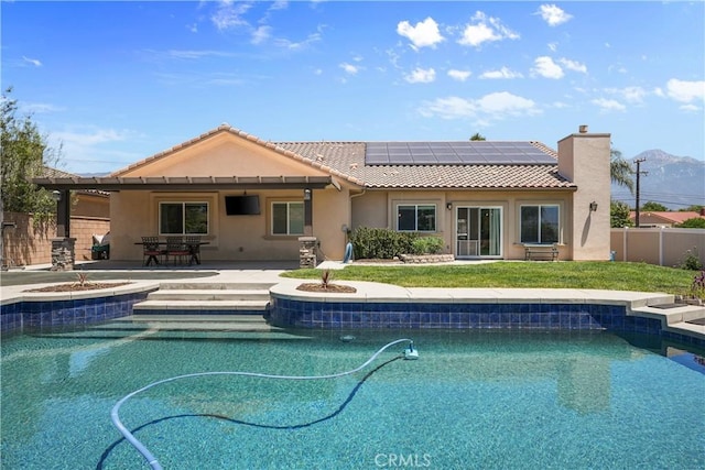 1018 W 15th St, Upland, CA 91786 - back of house with solar panels, stucco siding, a fenced backyard, a jacuzzi, and a tiled roof