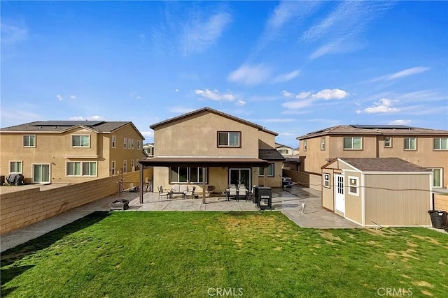 12465 Gramercy Ln, Victorville, CA 92392 - back of house with a fenced backyard, a patio area, a storage unit, and stucco siding