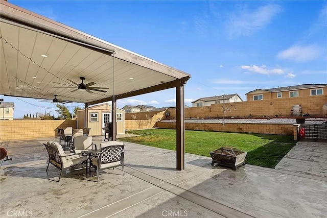 12465 Gramercy Ln, Victorville, CA 92392 - fenced backyard with an outdoor fire pit, a shed, a patio area, and ceiling fan