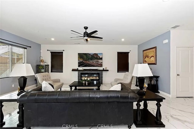 12465 Gramercy Ln, Victorville, CA 92392 - living area featuring light marble finish flooring, a ceiling fan, a glass covered fireplace, and recessed lighting
