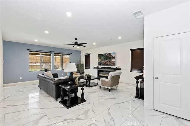 12465 Gramercy Ln, Victorville, CA 92392 - living room featuring recessed lighting, a ceiling fan, a glass covered fireplace, and light marble finish floors