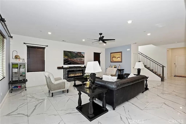 12465 Gramercy Ln, Victorville, CA 92392 - living room with stairs, a glass covered fireplace, light marble finish flooring, recessed lighting, and a ceiling fan