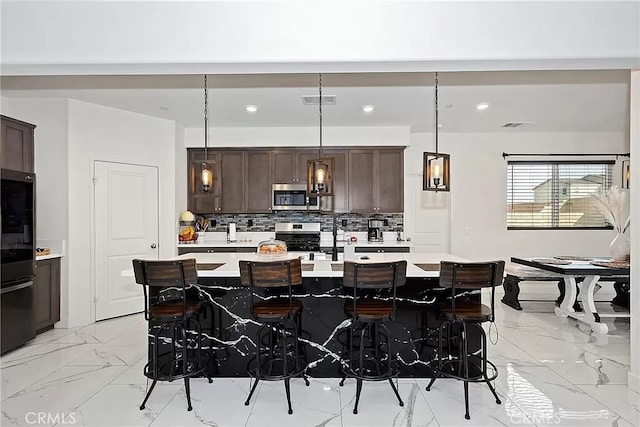 12465 Gramercy Ln, Victorville, CA 92392 - kitchen featuring stainless steel appliances, light countertops, light marble finish flooring, dark brown cabinetry, and recessed lighting