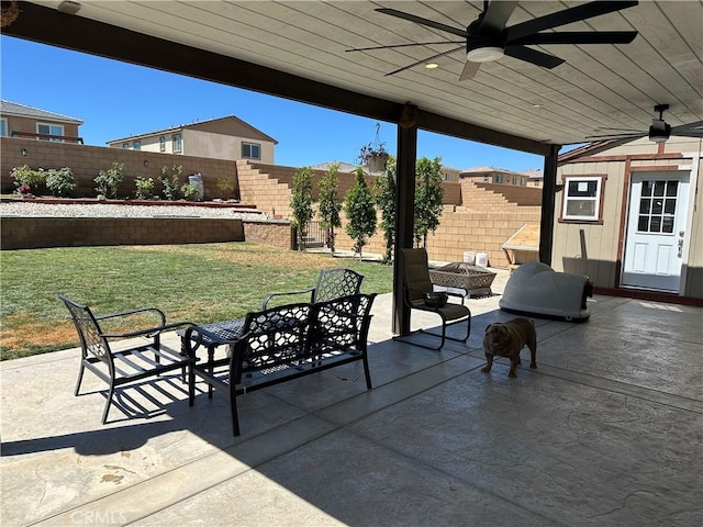 12465 Gramercy Ln, Victorville, CA 92392 - fenced backyard with a fire pit, a ceiling fan, a patio area, and an outbuilding