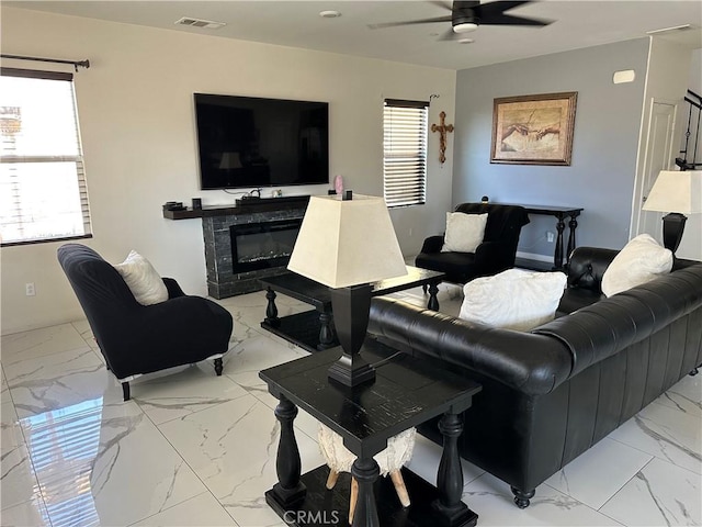 12465 Gramercy Ln, Victorville, CA 92392 - living area with light marble finish flooring, ceiling fan, and a glass covered fireplace